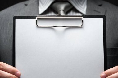 Beyaz boş kağıt sayfa, iş adamı eli, gri takım elbise, koyu duvar arkaplan, metin için boş alan