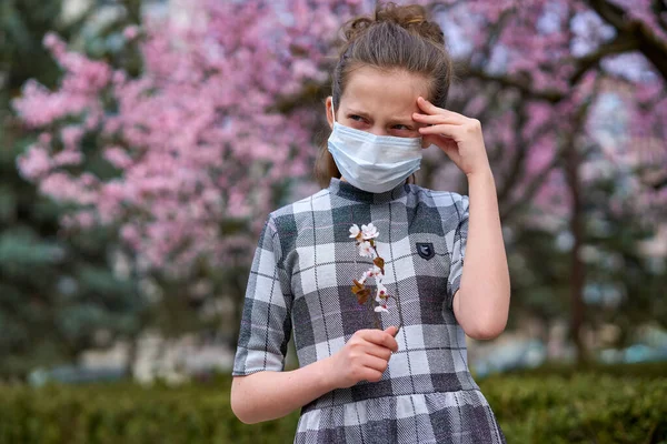 フェイスマスクを持つ女の子は街の屋外にあり 木を咲かせ 春の季節 開花時間 ほこりの多い空気からのアレルギーと健康保護の概念 — ストック写真