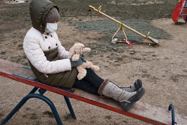 Concept Epidemic Quarantine Girl Face Mask Cuddly Toy Alone Playground — Stock Photo, Image