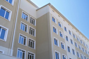 Birçok penceresi olan çok katlı yeni bir binanın ön cephesi