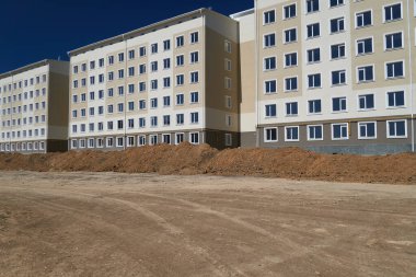 İnşaat süreci ve ev alanının geliştirilmesi, arazi derecelendirmesi veya toprak çalışması, çok katlı yeni bir binanın ön cephesi