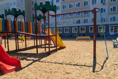 İnsanların olmadığı bir şehir altyapısı. Bir apartmanın yanındaki çocuk parkı. Salla, kay, merdivenler, çok katlı bina. Çocukların oynayabileceği bir yer..