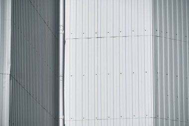 Duvara beyaz metal kaplama ve arka plan olarak boşaltma borusu