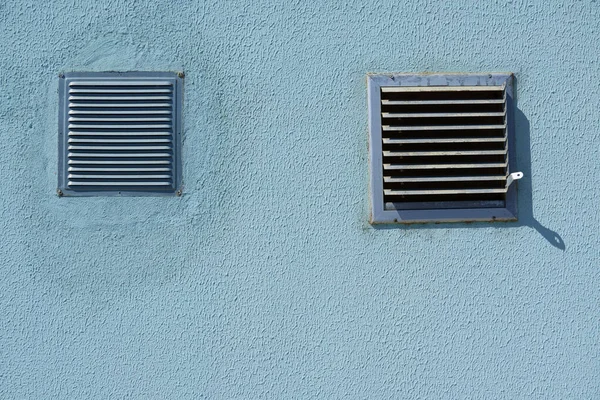 Square metal ventilation grate in a blue wall, close view, delivers fresh air and cools — Stock Image Square Metal Ventilation Grate Blue Wall Close View Delivers Fresh Royalty Free Stock Photos
