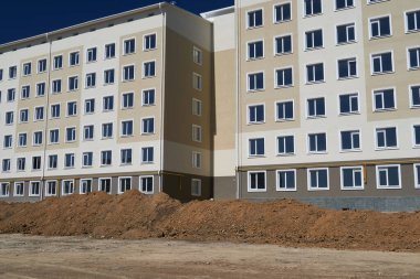 İnşaat süreci ve ev alanının geliştirilmesi, arazi derecelendirmesi veya toprak çalışması, çok katlı yeni bir binanın ön cephesi