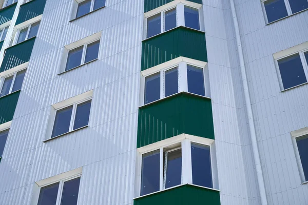 新的多层建筑的正面 有白色和绿色的金属边框 许多窗户 — 图库照片
