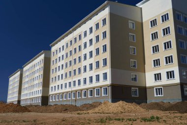 İnşaat süreci ve ev alanının geliştirilmesi, arazi derecelendirmesi veya toprak çalışması, çok katlı yeni bir binanın ön cephesi
