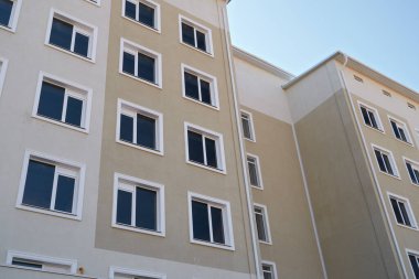 Birçok penceresi olan çok katlı yeni bir binanın ön cephesi