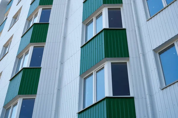 新的多层建筑的正面 有白色和绿色的金属边框 许多窗户 — 图库照片