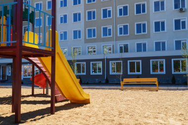 İnsanların olmadığı bir şehir altyapısı. Bir apartmanın yanındaki çocuk parkı. Salla, kay, merdivenler, çok katlı bina. Çocukların oynayabileceği bir yer..