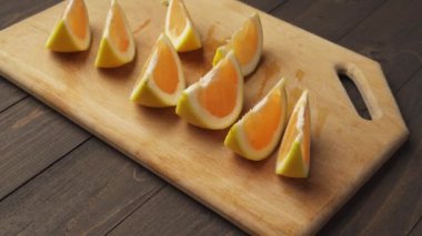 Tahta bir masada taze portakallar, bütün ve dilimlenmiş. Bir tabak dolusu turunçgil dilimi.. 