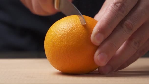 近距离观察一只手将橙子切成两半以便在切菜板上做新鲜果汁 — 图库视频影像