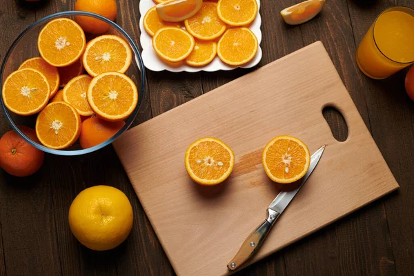 新鲜的橙色水果 切块放在木制桌子上 切块和菜刀上 一盘柑橘片 天然健康的食物 一杯水果鸡尾酒 — 图库照片