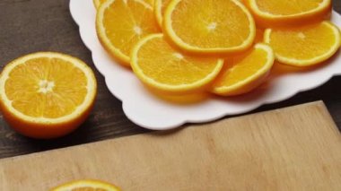 Mutfak kesim tahtasında portakal meyvesi dilimlemek, arka plan olarak ahşap masa, yakın görüş..