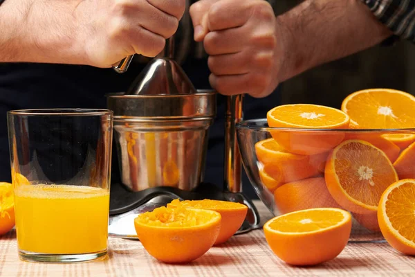 手動プレスでオレンジ色を絞り ビューを閉じ 新鮮なガラスを作ります 木のテーブルの上に新鮮なオレンジ 圧迫し スライス — ストック写真