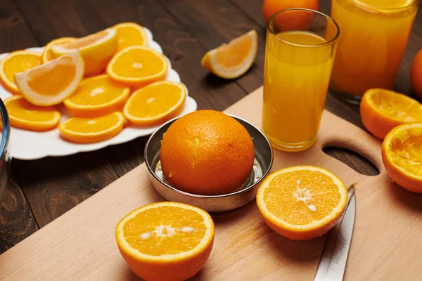 新鲜的橙色水果 切块放在木制桌子上 切块和菜刀上 一盘柑橘片 天然健康的食物 一杯水果鸡尾酒 — 图库照片