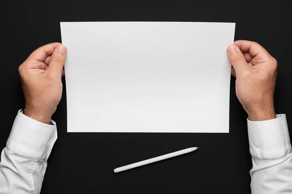 Uma Folha Papel Branco Mãos Empresário Sobre Uma Mesa Preta — Fotografia de Stock