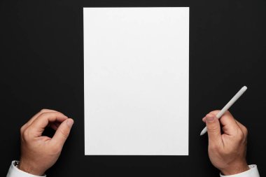 boş bir kağıt ve siyah bir masa üzerinde bir işadamı elleri, beyaz bir gömlek ve bir kol saati, herhangi bir yazı veya yazı için üst görünüm şablonu