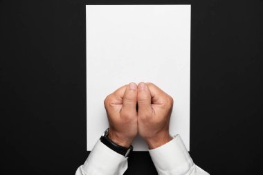 boş bir kağıt ve siyah bir masa üzerinde bir işadamı elleri, beyaz bir gömlek ve bir kol saati, herhangi bir yazı veya yazı için üst görünüm şablonu