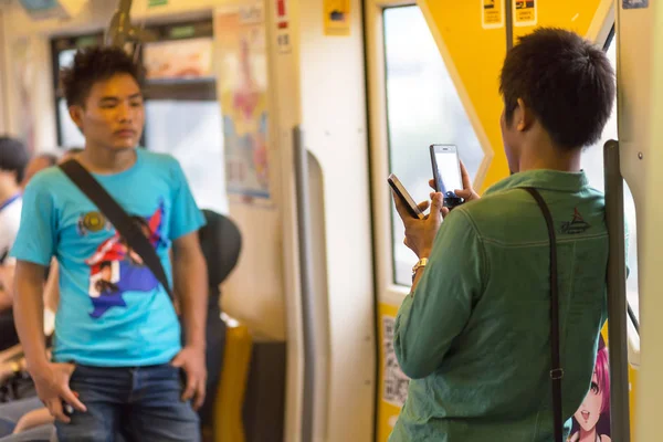 Using smartphone in public transportation — Stock Photo, Image