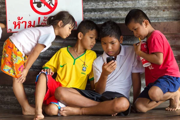 Niños asiáticos viendo la pantalla del teléfono inteligente —  Fotos de Stock