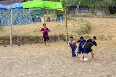 Ricefield içinde futbol oynayan çocuklar