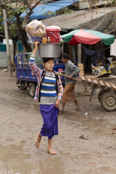 Birman kadının kafasına çanta taşıyor — Stok fotoğraf