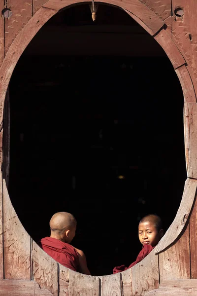 Jóvenes monjes budistas riéndose de una ventana — Foto de Stock