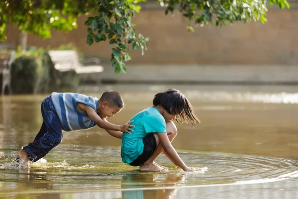 孩子们在一个水坑里玩耍 — 图库照片