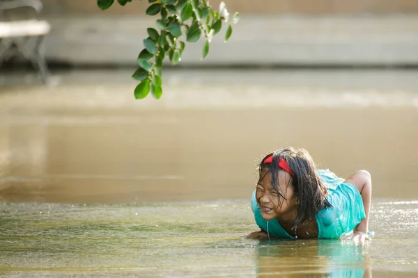 小女孩躺在一个水坑里 — 图库照片