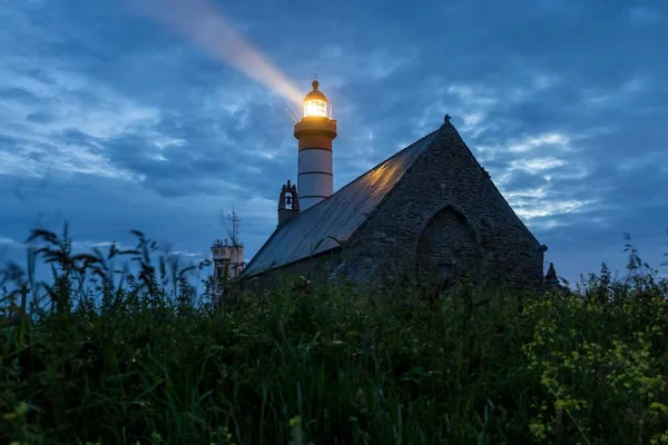 Twilight lighthouse and church — Stock Photo, Image