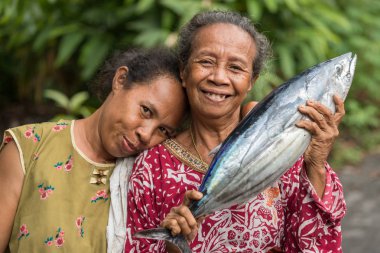 Women showing fresh Skipjack fish clipart