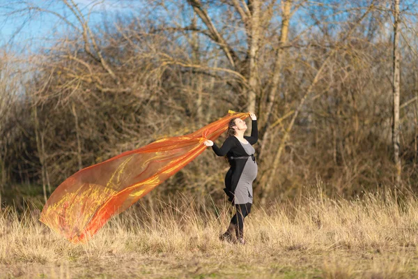 Zwangere vrouw in het park met zijden sjaal — Stockfoto