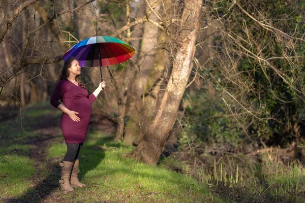 Zwangere vrouw met een kleurrijke paraplu — Stockfoto