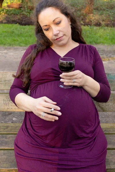Gravid kvinna med alkohol och cigarett i parken — Stockfoto