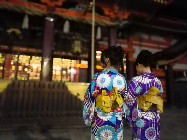 Japanese girls pray at Yasaka shrine, Kyoto