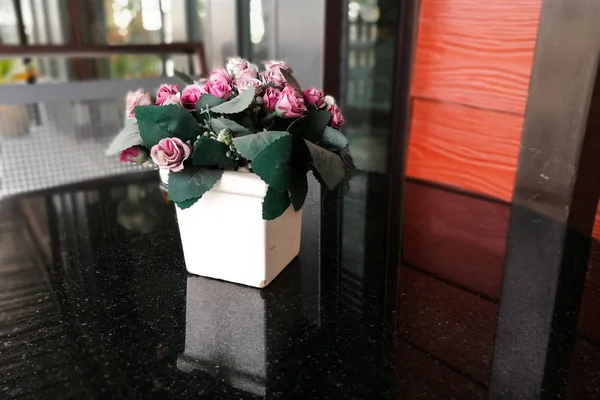 Поддельные цветы роз на столе — стоковое фото