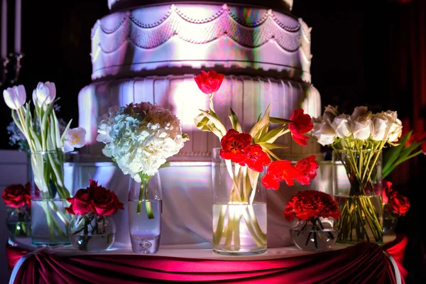 Blommor nära bröllopstårta — Stockfoto