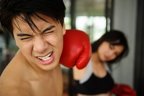 Człowiek twarz pięścią przez rękawice bokserskie prawej dziewczyna — Zdjęcie stockowe