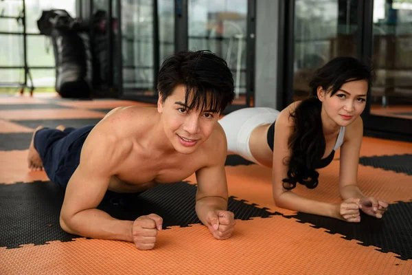 Muscular asiática sonrisa pareja planking en fitness — Foto de Stock