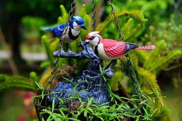 Kleurrijke keramische vogels op hangende bloempotten — Stockfoto