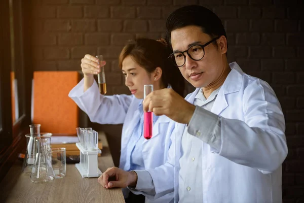 Two scientist test chemical liquid in lab