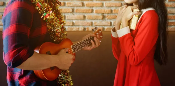 Jong koppel vieren Kerstmis met ukulele — Stockfoto