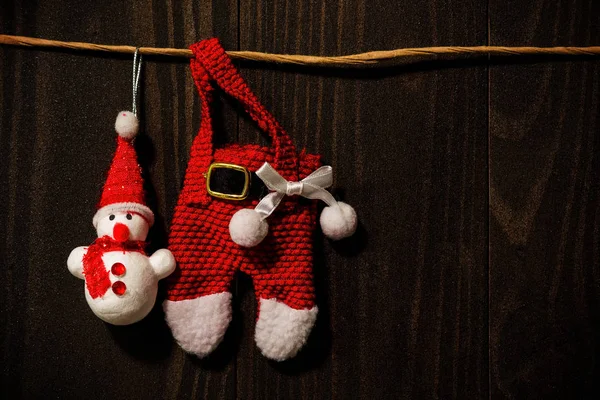 Санта Клаус и снеговик зависают на тёмной деревянной стене — стоковое фото