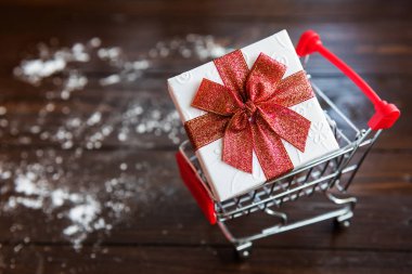 Alışveriş sepeti üzerinde Noel hediye kutusu 