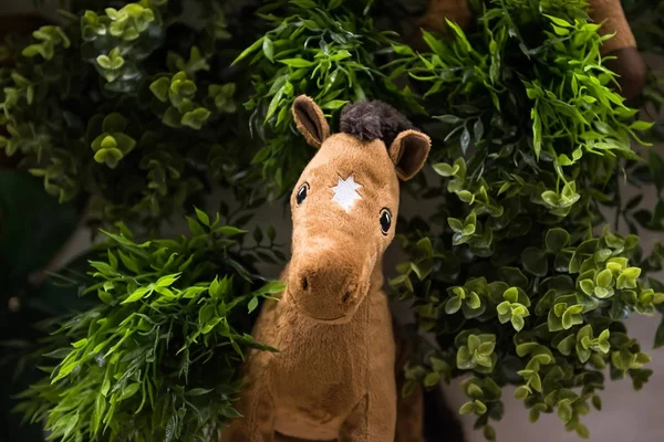 Paard pop op nep groene plant — Stockfoto