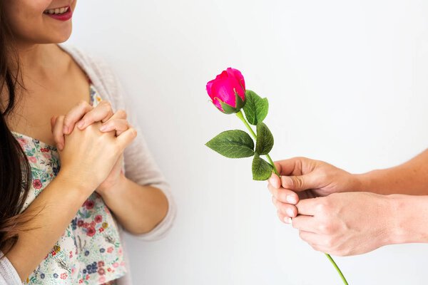 Man hand giving pink rose to girlfriend