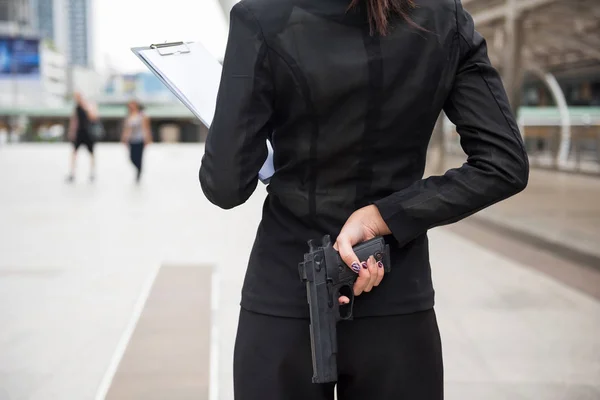 Mujer con vestido de negocios ocultar arma en la espalda — Foto de Stock