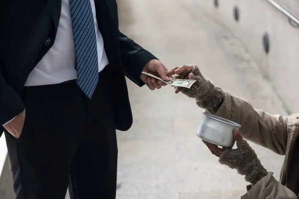ビジネスの男性は、乞食にお金を与える — ストック写真