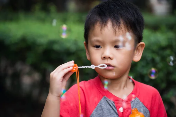 Cute boy blowing soap bubble — Stock Photo, Image